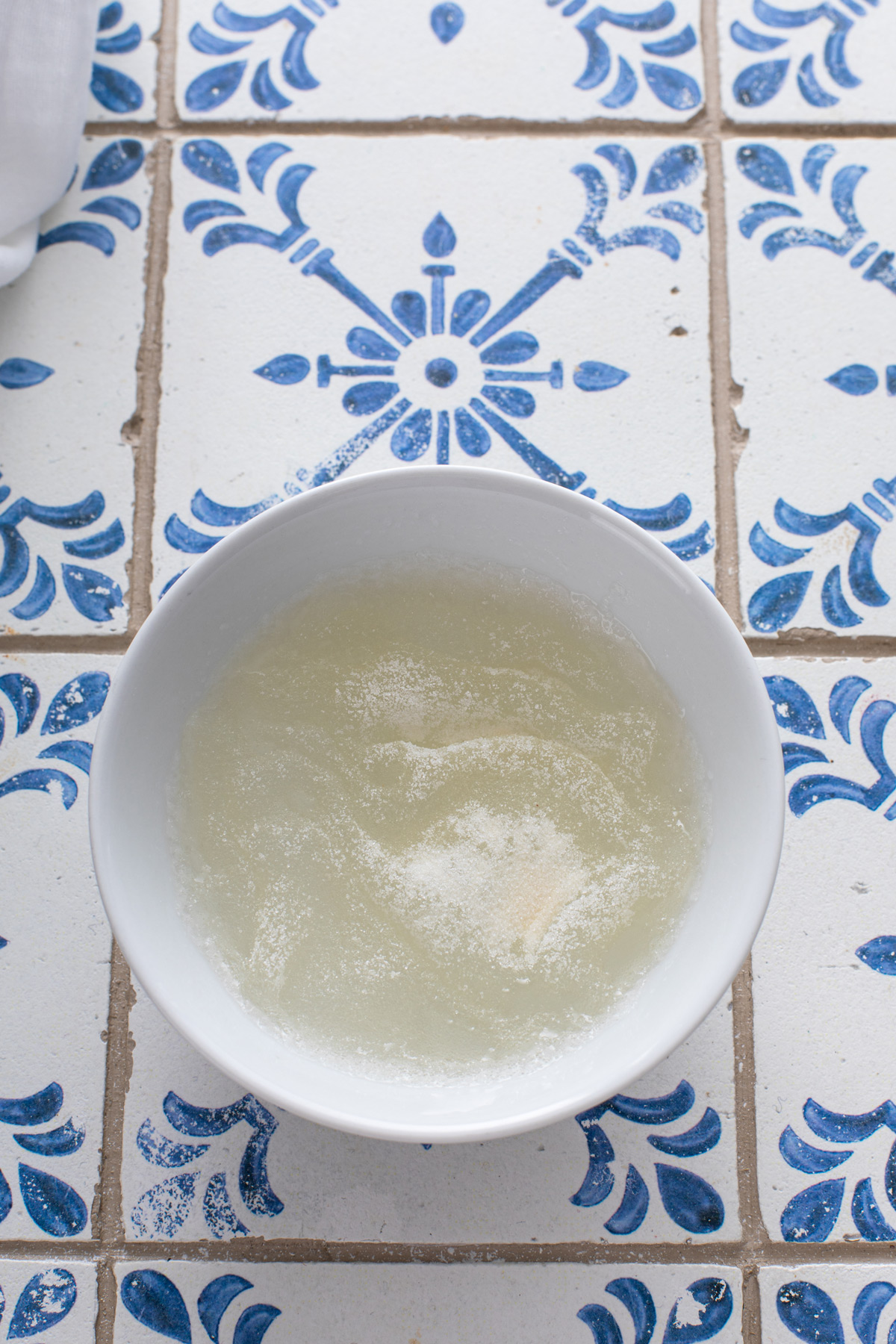 Powdered unflavored gelatin blooming in a bowl of water.