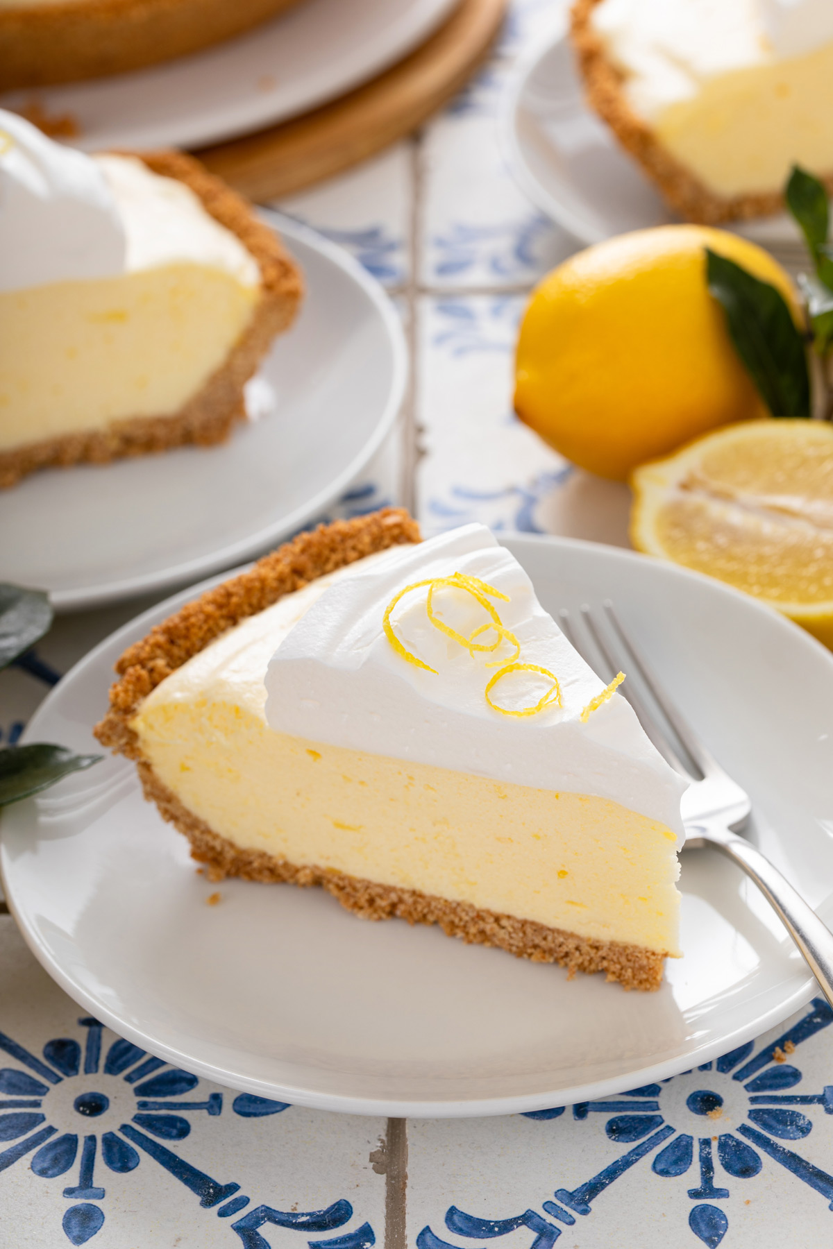 slice of Lemon chiffon pie and a fork on a white plate.