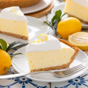 Two plated slices of lemon chiffon pie on white plates.