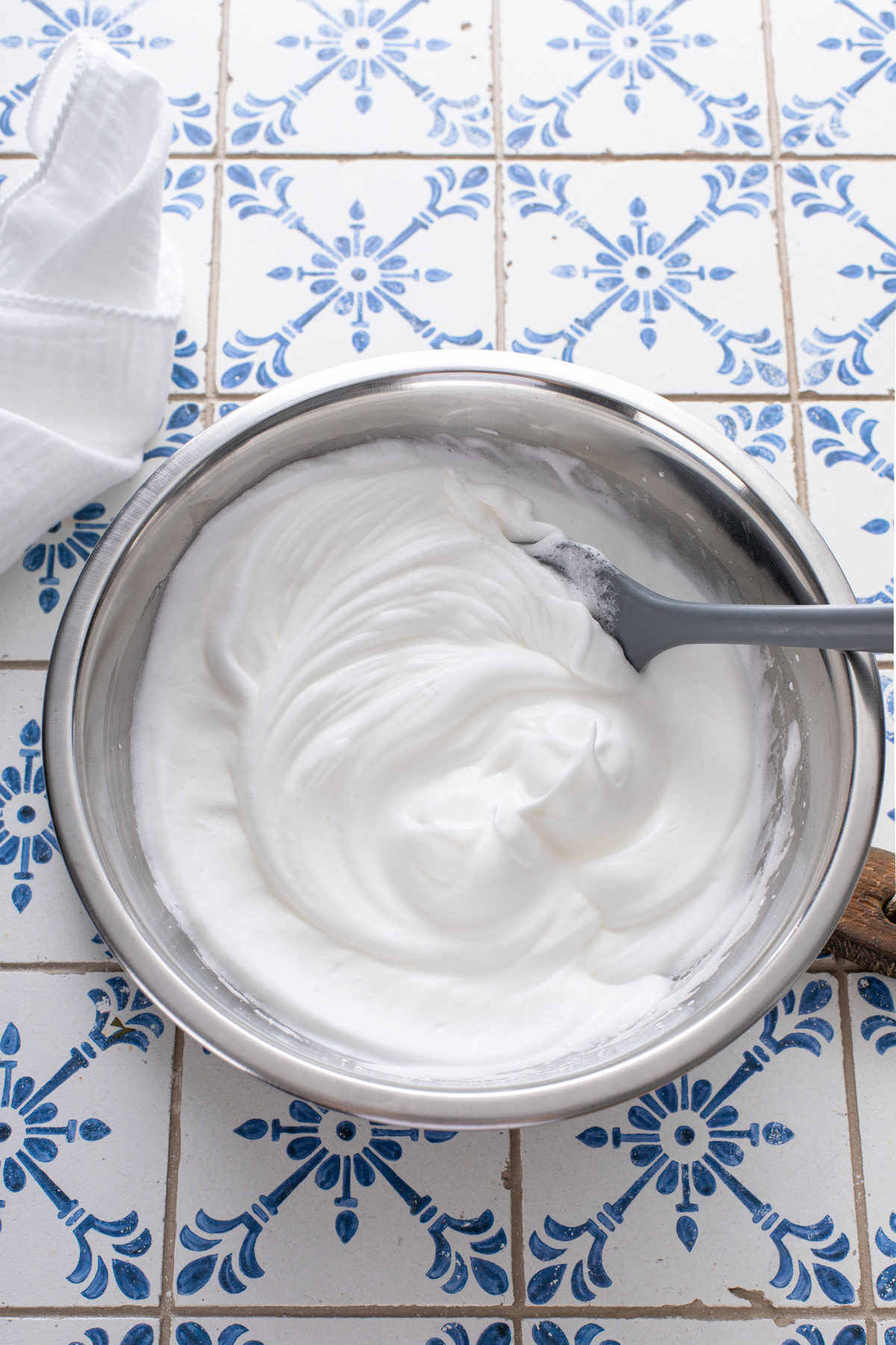 Egg white meringue beaten in a metal bowl.